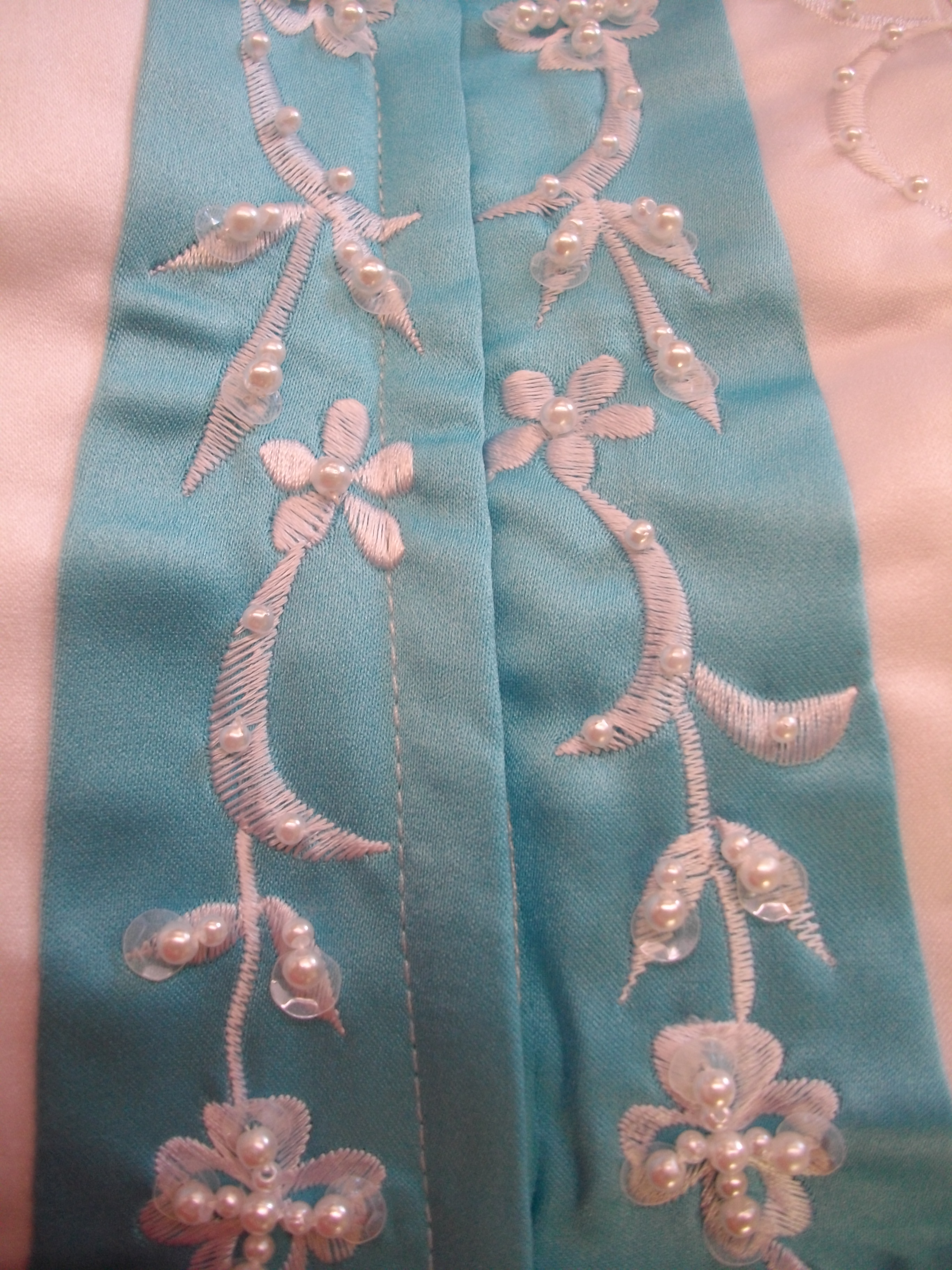 White beaded embroidery on pool blue wedding dress trim