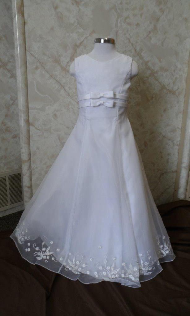 Long Sleeveless white flower girl dress with double bow waist, sheer overlay and floral embroidered hemline, on sale.