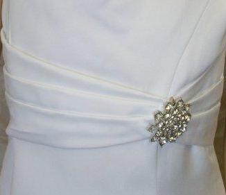 Asymmetrical pleated empire waistline with shimmering brooch