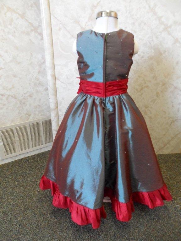 teal dress with apple red sash and ruffled hemline