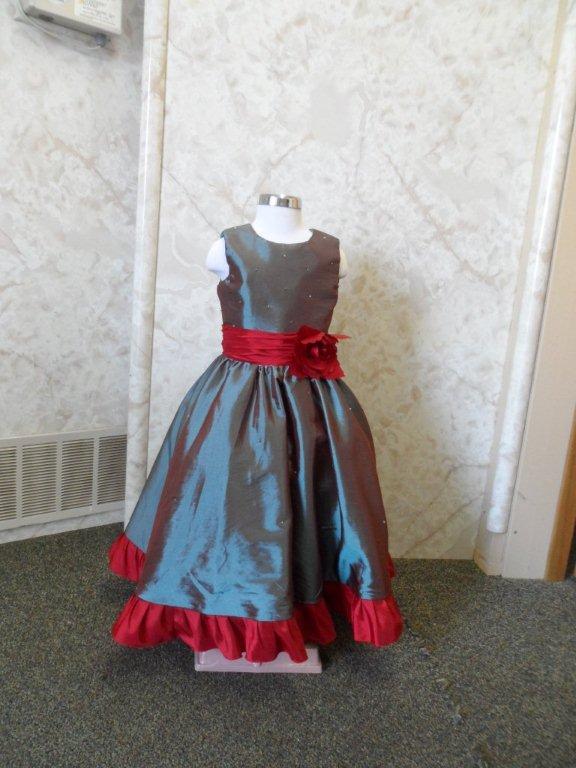 teal dress with apple red sash and ruffled hemline