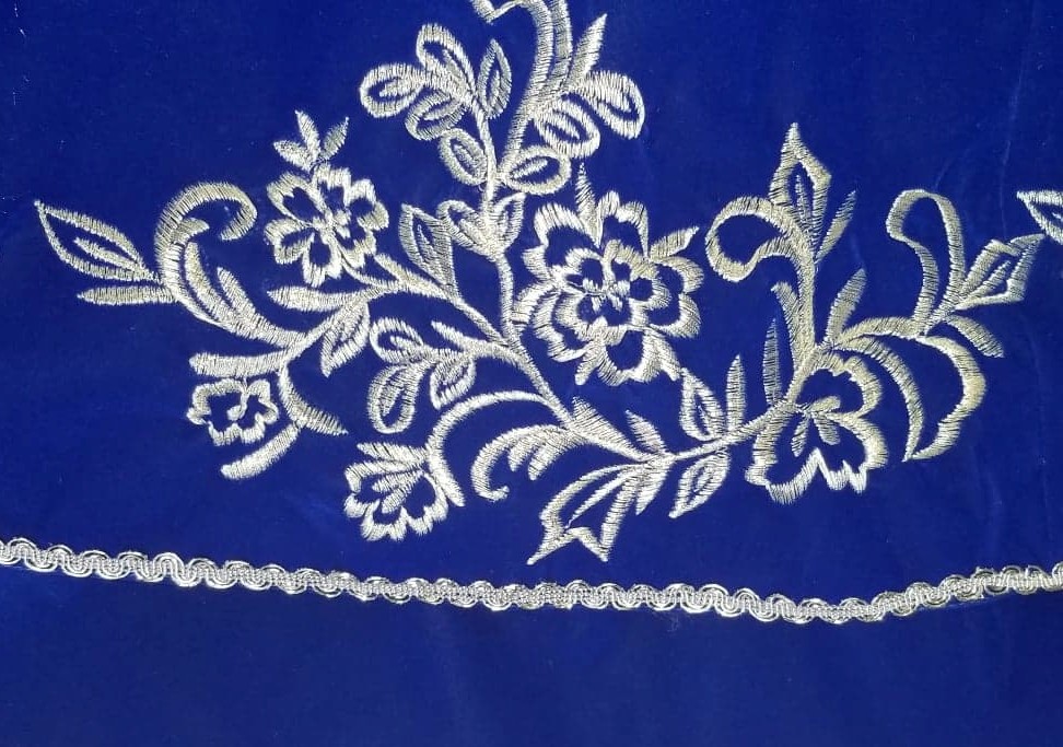 white embroidery on blue velvet
