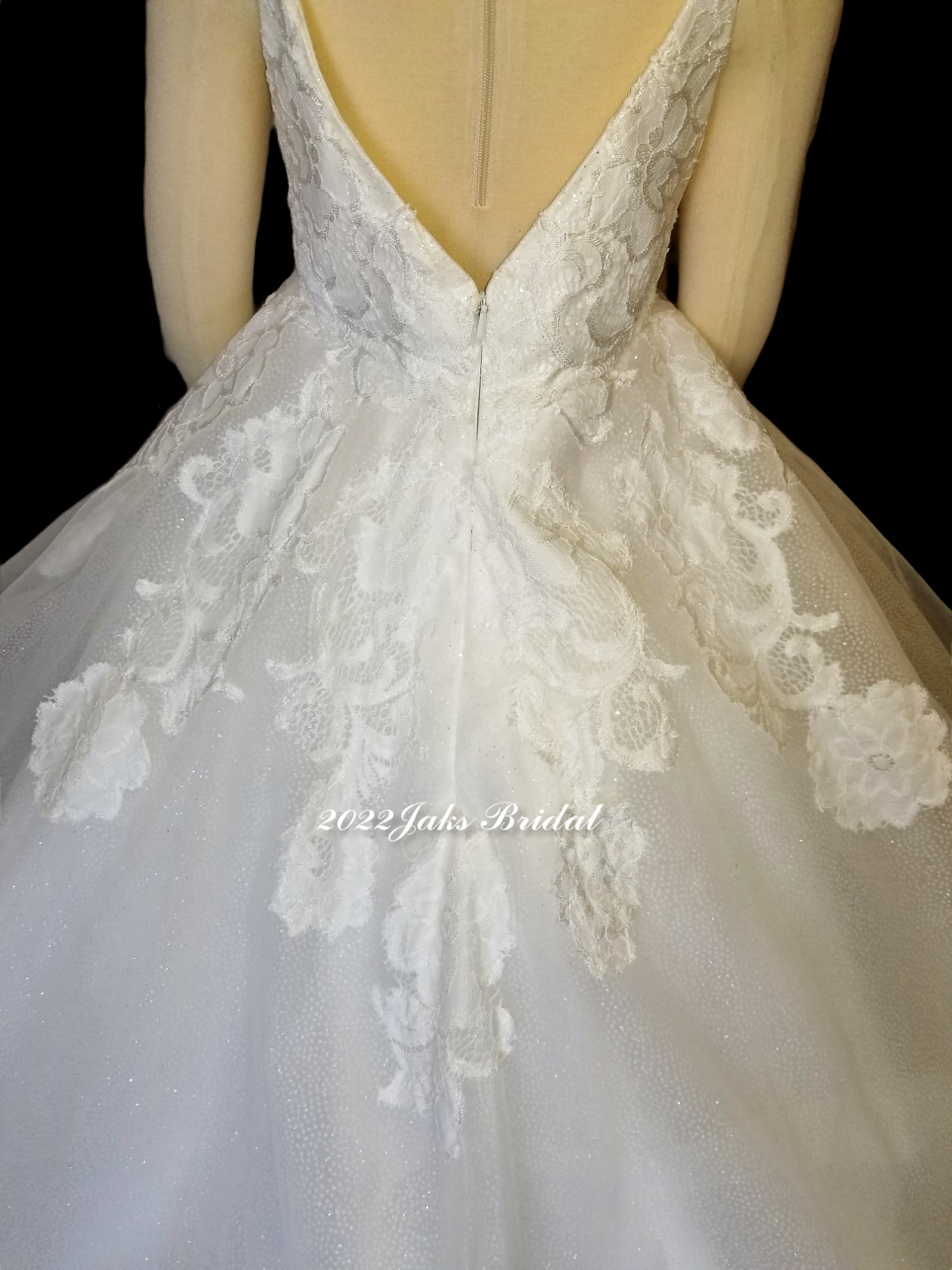 Flower girl dress with plunging neckline, illusion modesty panel, side cut outs, full tulle skirt with lace appliques.