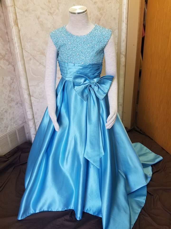 blue floor length girls pageant dress with pearl and rhinestone beaded empire bodice with bow front