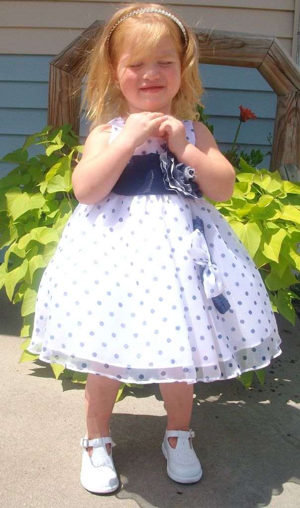 White baby or toddler dress with navy blue polka dots.