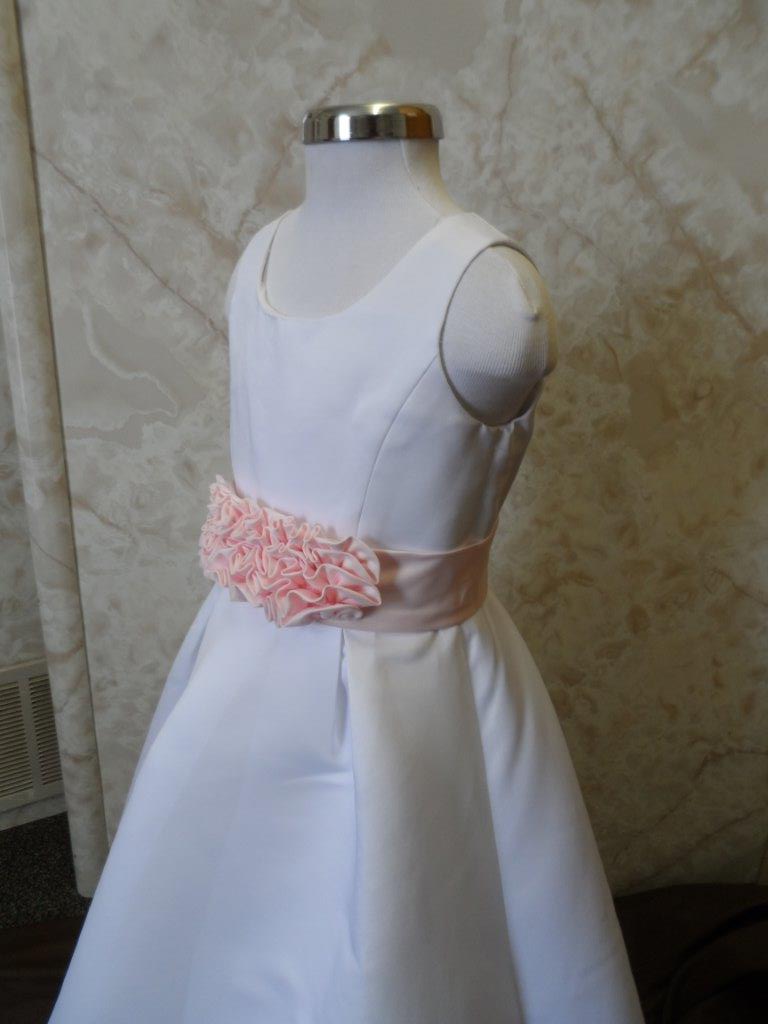 Ivory or White long dress with attractive pink cummerbund sash and ruffled bow accent.