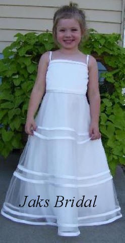 This white flower girl dress has an illusion tulle skirt with rows of satin banding around the skirt size 5.