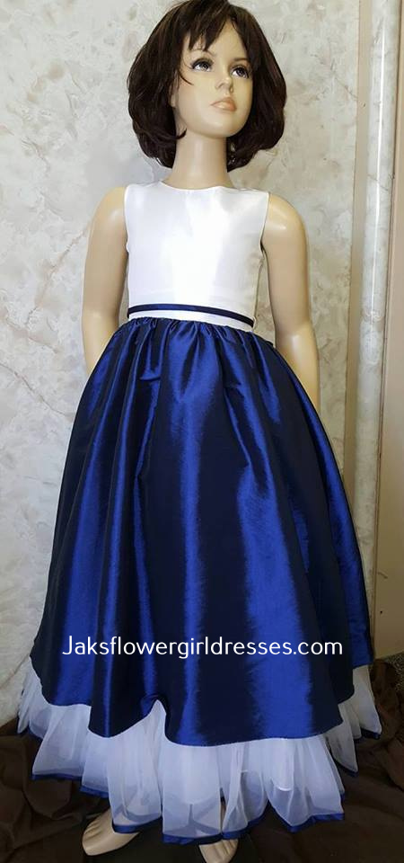Sleeveless flower girl dress.  White bodice and ruffled hemline, accented with a royal blue skirt.