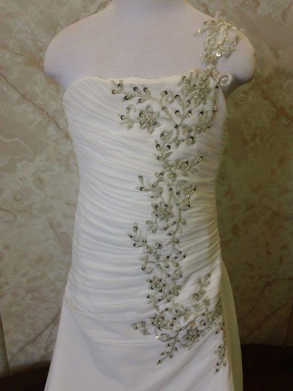 Applique beaded strap flows down this ruched dress