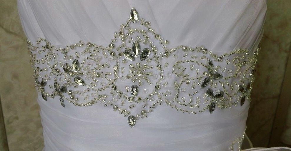 ruched bodice is edged with a jeweled belt