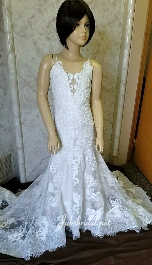 Embroidered lace flower girl dress with beaded spaghetti straps.  Covered buttons extend to the hemline of the train. 