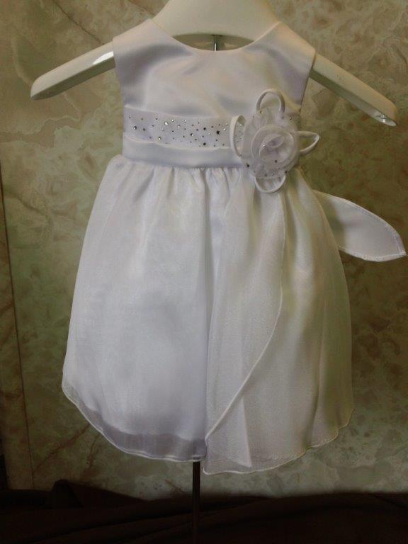 white infant dress with sequins and ribbon flower