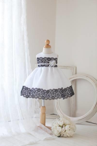 white size large baby dress with black lace trim on the waist and hemline.