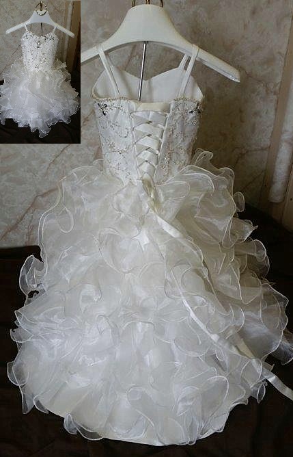 Charming child wedding dress is decked out with a sweetheart beaded bodice and elaborate organza ruffle skirt with train. 