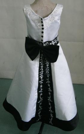 White sleeveless dress with black trim and rich embroidery
