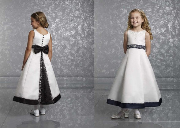  White Sleeveless Flower Girl Dress. Black contrasting covered buttons, bow and trim
