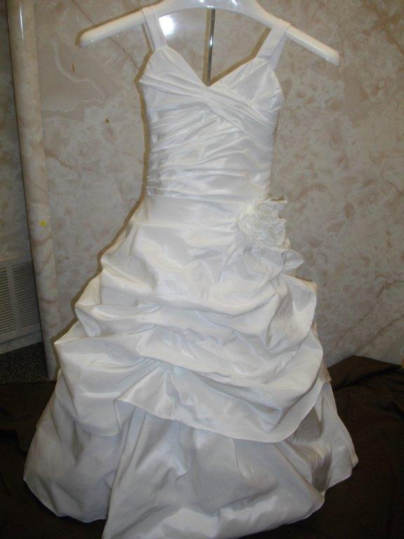 bridal gown has wide straps with a draped pick-up layer over an A-line skirt